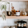 9oz Bayberry Cedar Soy Candle lit on kitchen shelf. 