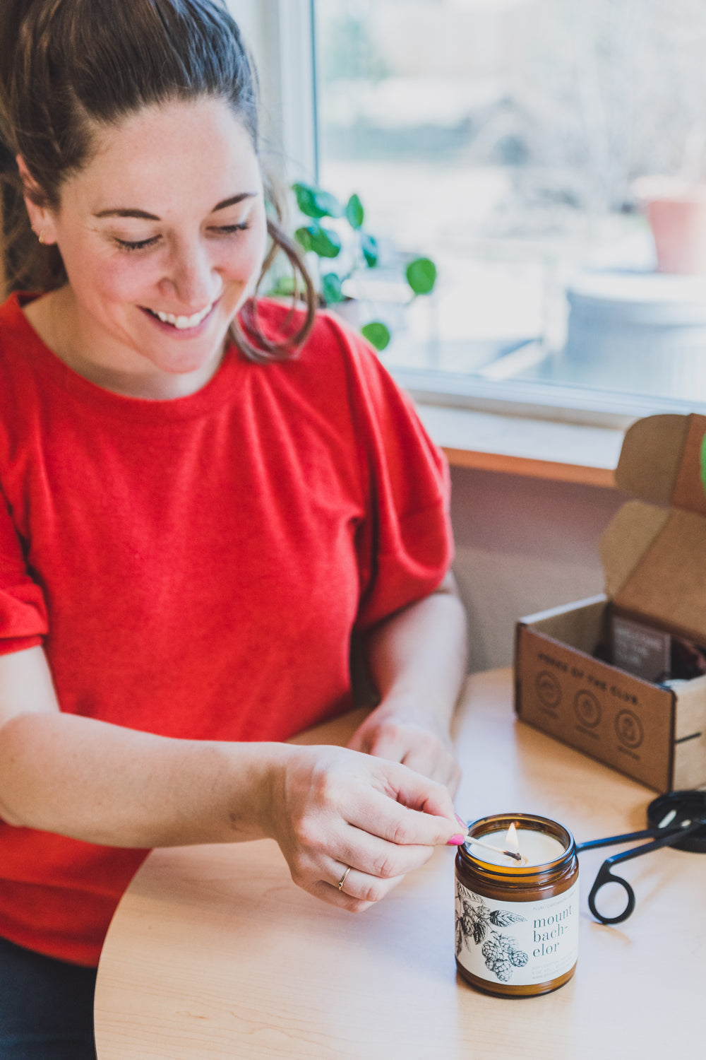 9oz Mount Bachelor Soy Candle being lit by a woman with a match. 