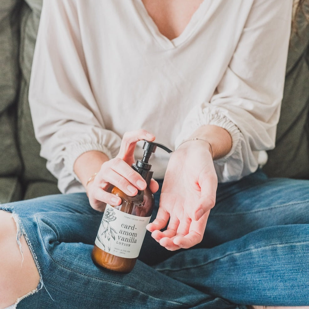 8oz Cardamom Vanilla Body being dispensed into a woman's hand. 