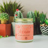 9oz 'Yeehaw' Soy Candle on a countertop with various small plants. 