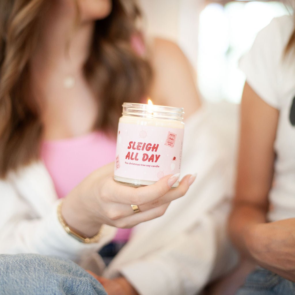 'Sleigh All Day' 9oz Soy Candle being held by a woman. 