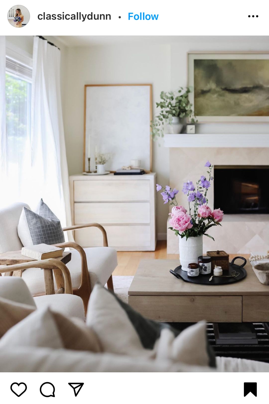 A neutral living room with fresh flowers and Broken Top Brands Soy Candles on the coffee table. 