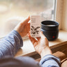 Fresh Squeezed Soy Wax Melt being held by two hands in front of a window and wax melter on the window sill. 