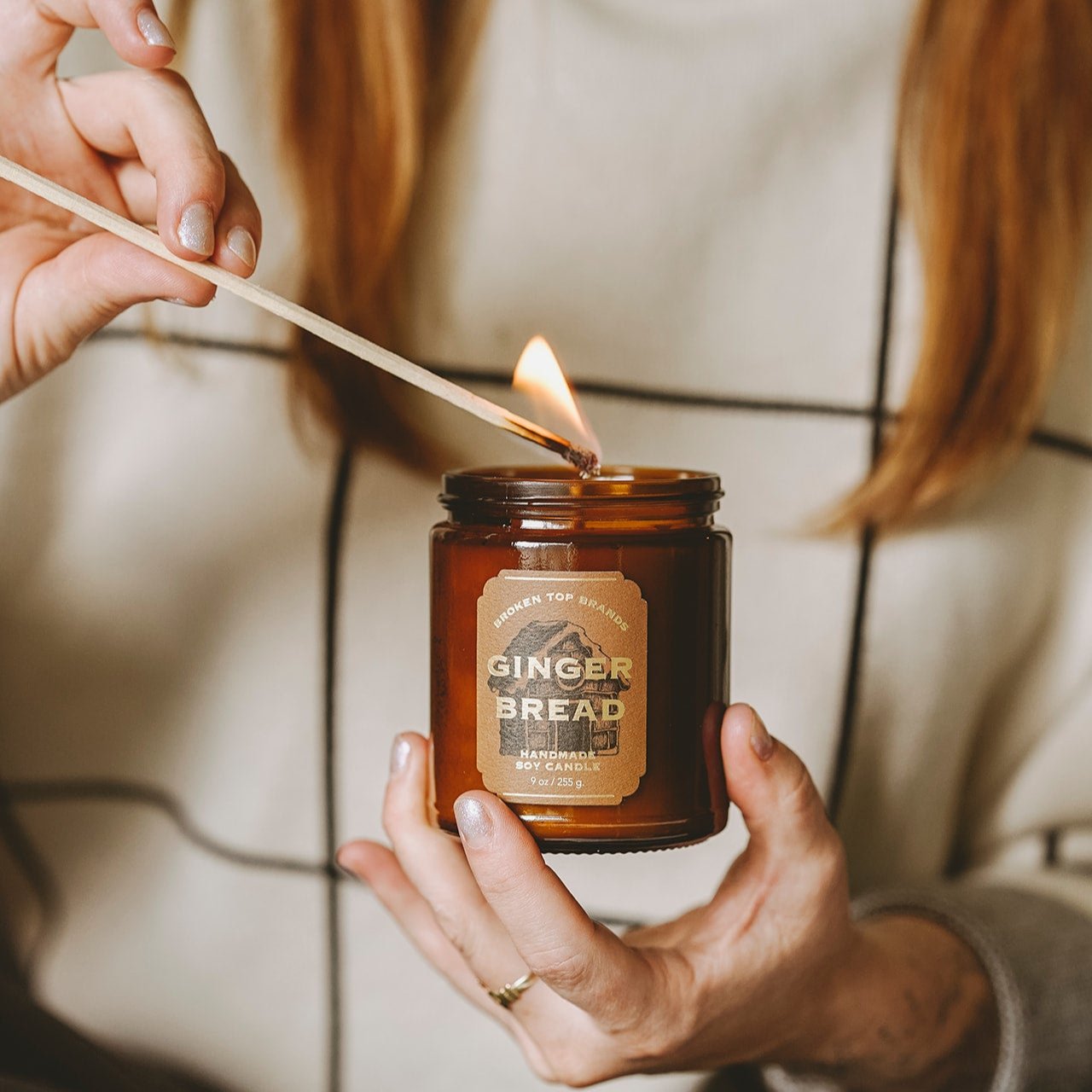 9oz Gingerbread Soy Candle being lit by a match.