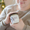 9oz Mango Guava Soy Candle being held by a young woman. 