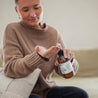 Mount Bachelor 8oz Body Lotion being dispensed into hands by a woman. 