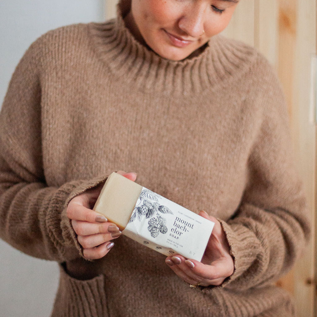 Mount Bachelor Bar Soap being unwrapped by a woman's hands. 