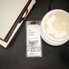 Lavender Mint Soy Wax Melt on black side table next to a white wax melter and stack of books. 