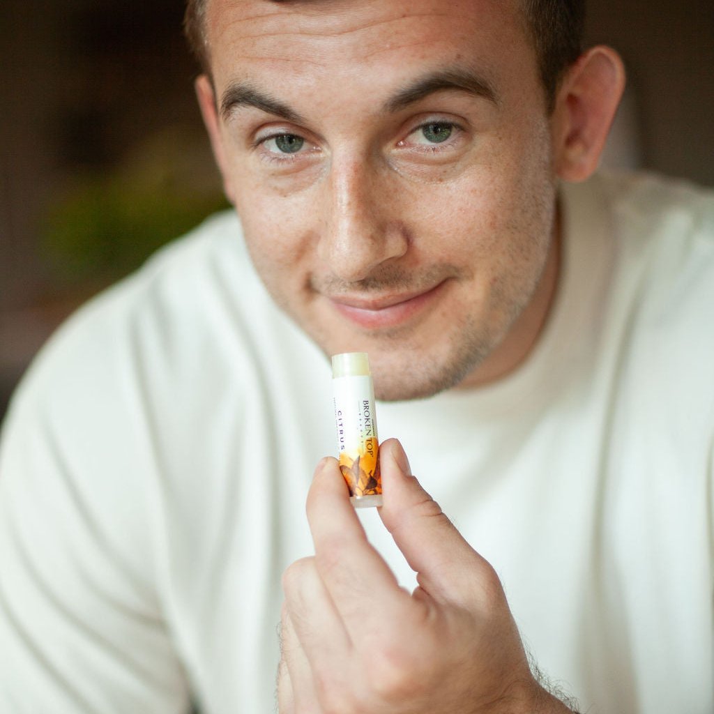 Citrus Lip Balm being held by a man.