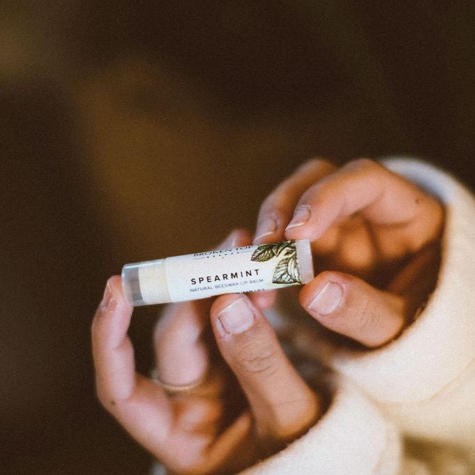 Spearmint Lip Balm being held by woman's hands. 