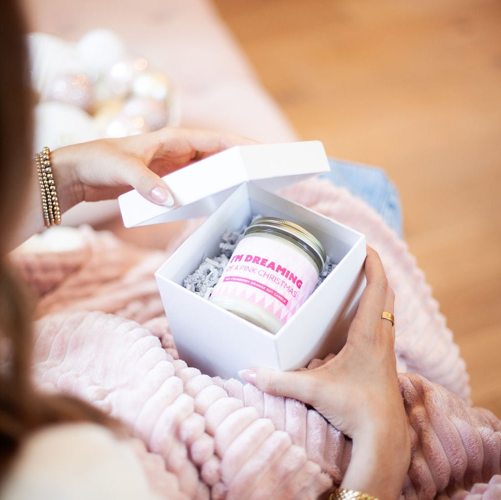 'I'm Dreaming of a Pink Christmas' 9oz Soy Candle being opened in a gift box. 