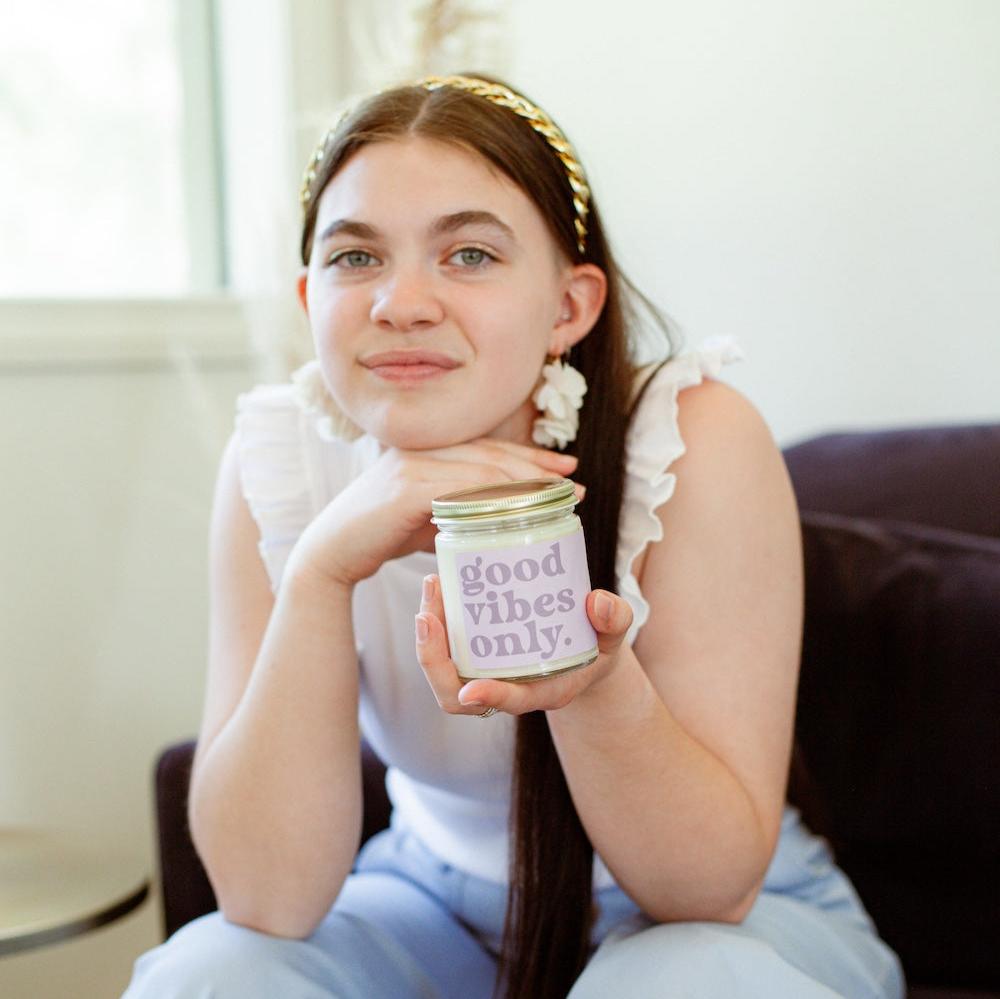 9oz 'Good Vibes Only' Soy Candle being held by a young woman. 