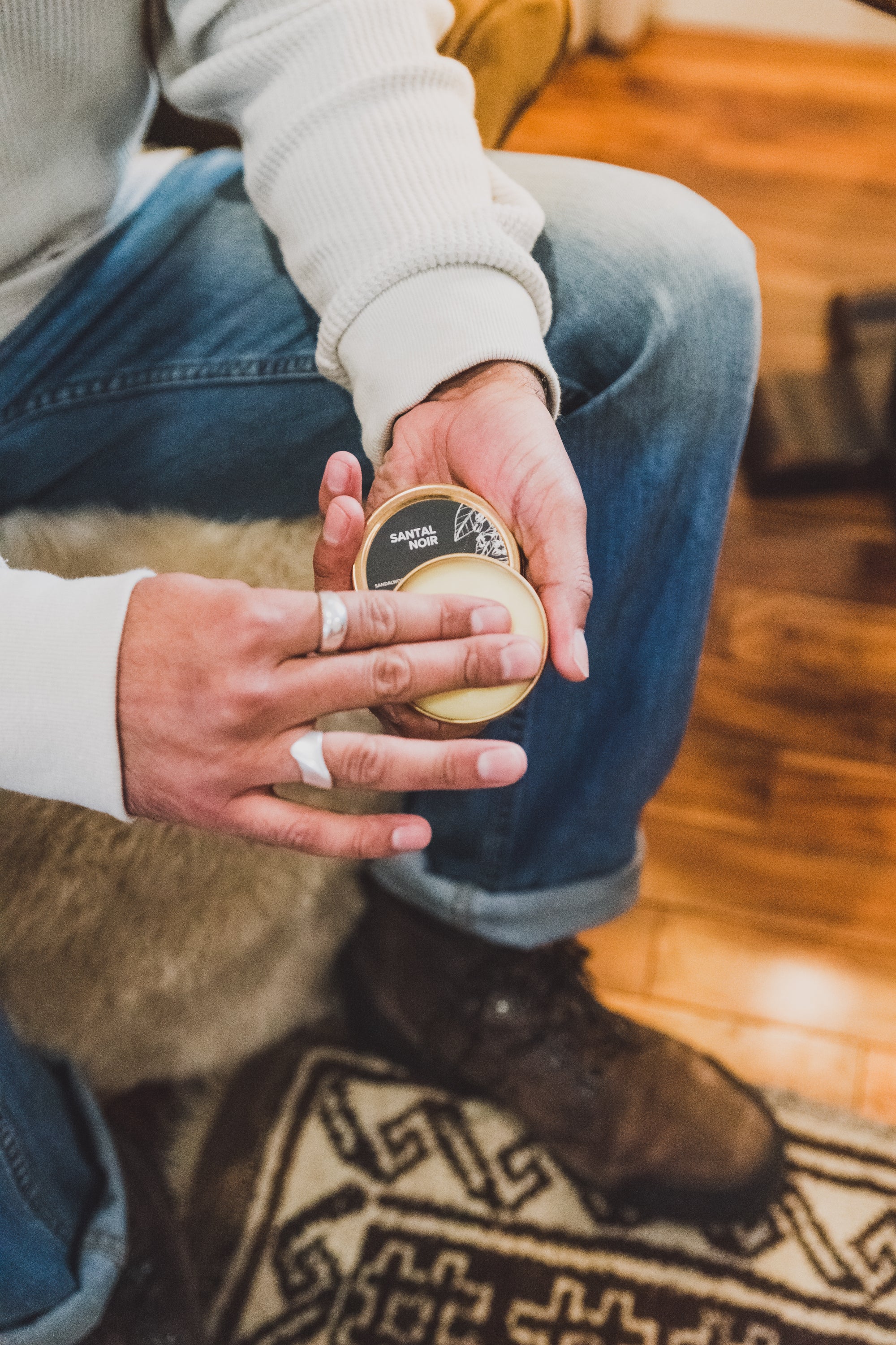 Santal Noir Solid Cologne being held by a man's two hands. 