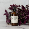 8oz Spiced Winter Plum Liquid Soap in front of a purple plant. 