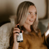 4oz White Birch Linen Spray being sprayed by a woman. 