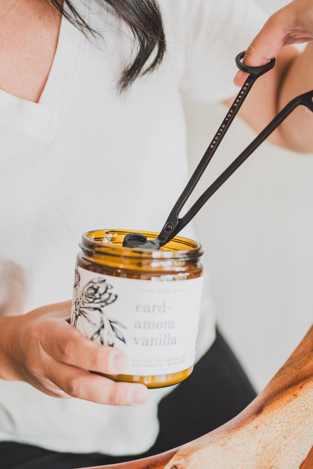 Black Broken Top Brands Wick Trimmer being used to trim the wick of a 16oz Cardamom Vanilla Soy Candle. 