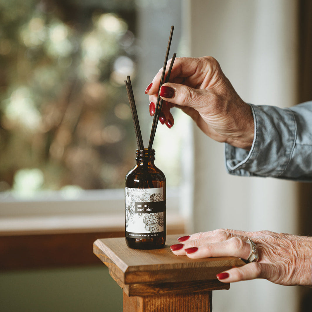 Mount Bachelor Reed Diffuser being adjusted by two hands. 